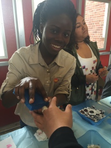Freshman Comfort Akuamoah-Boateng prepares to give a student a temporary tattoo. Tattoos were available on Tuesday in the B-Wing Atrium.
